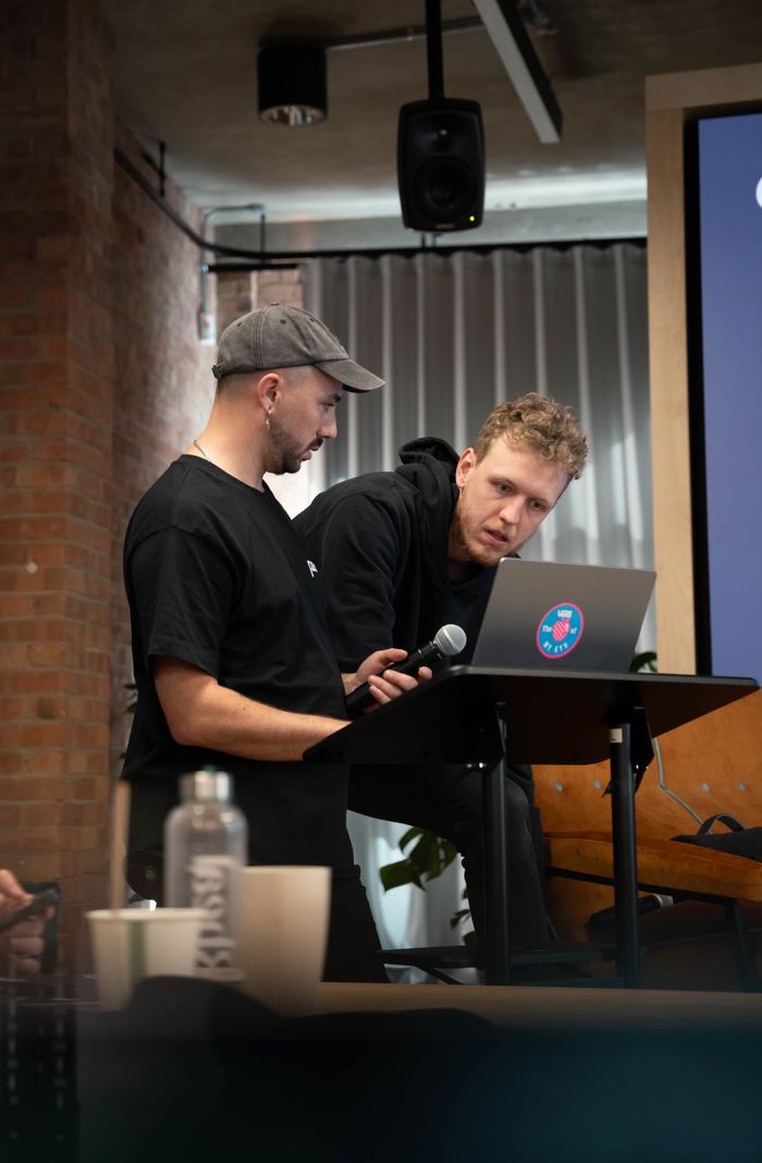 Service Two men collaborating during a presentation at an indoor conference setting.